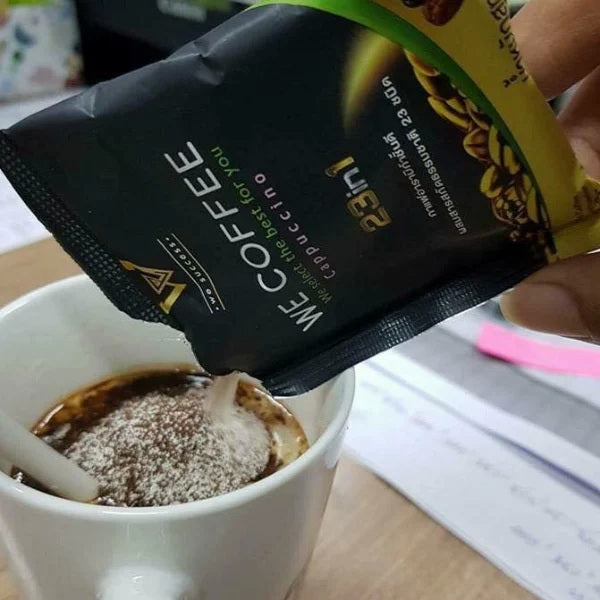 WE Coffee 23 in 1 Instant Arabica Cappuccino Herbal Mix being poured into a cup.
