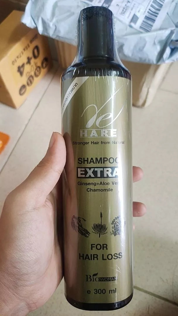 Hand holding a bottle of Biowoman Re Hare Shampoo Extra showing the front label and herbal ingredients