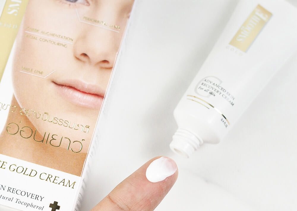 Smooth E Gold Cream texture being applied to a finger near the packaging