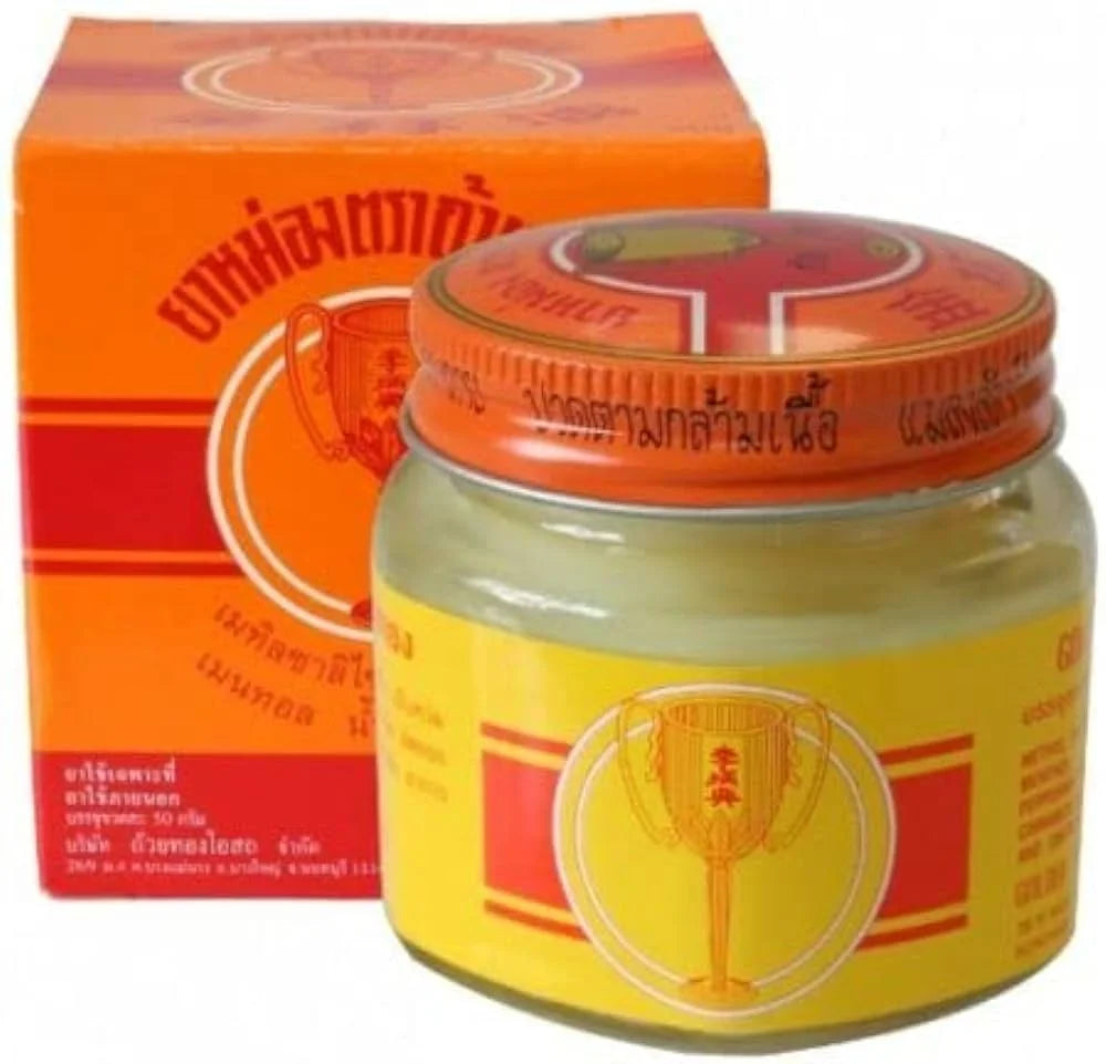 Golden Cup Balm Thai herbal yellow ointment in glass jar for sore muscles and stiffness
