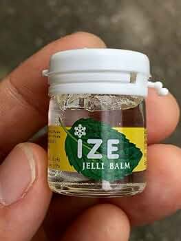 Hand holding IZE Jelli Balm Inhaler small 7g jar for quick dizzy relief