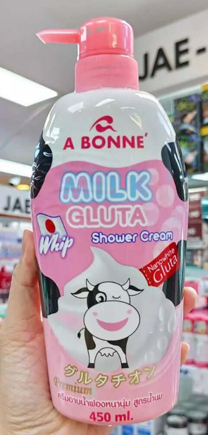 Hand holding an A Bonne Milk Gluta Shower Cream bottle in a store setting showing front label details.