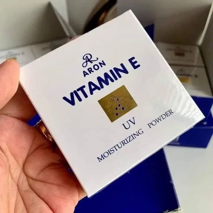 ARON Vitamin E Face Powder box held in hand, labeling moisturizes and provides UV protection.