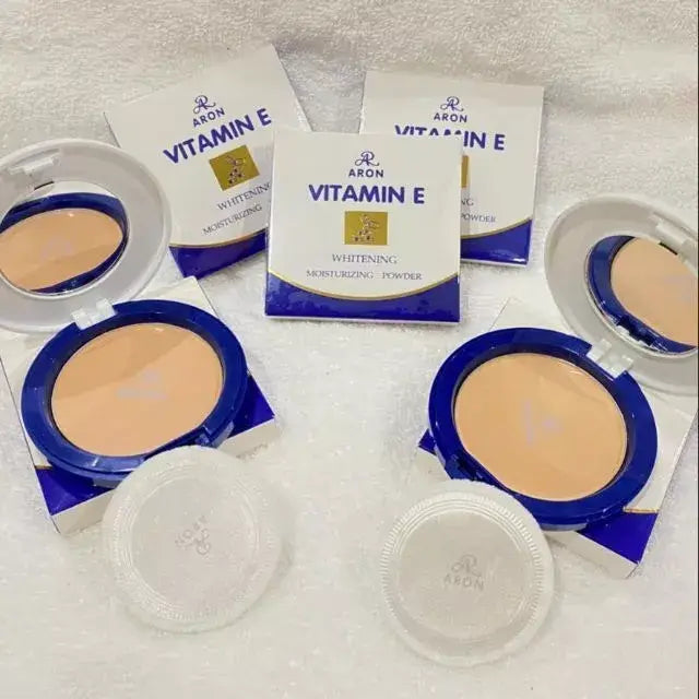 ARON Vitamin E Face Powder in compact packaging for moisturizing UVA UVB protection, displayed on a soft surface.