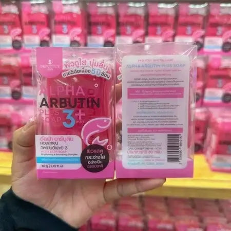 Alpha Arbutin Soap held in hand displaying front and back package on retail store shelf