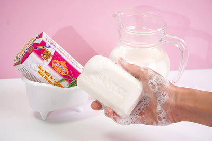 Lathered Asantee Rice Milk Soap bar held in hand with rich foam
