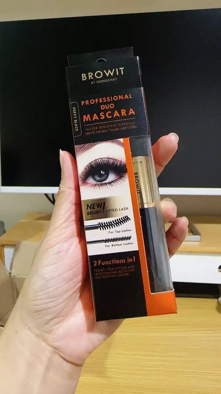 Real-life photo of a hand holding the BROWIT Professional Duo Mascara packaging box in an indoor setting.