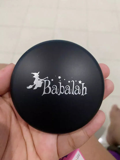 Babalah Becca Powder Cake compact with black matte finish and silver logo, showcasing the brand's signature design.
