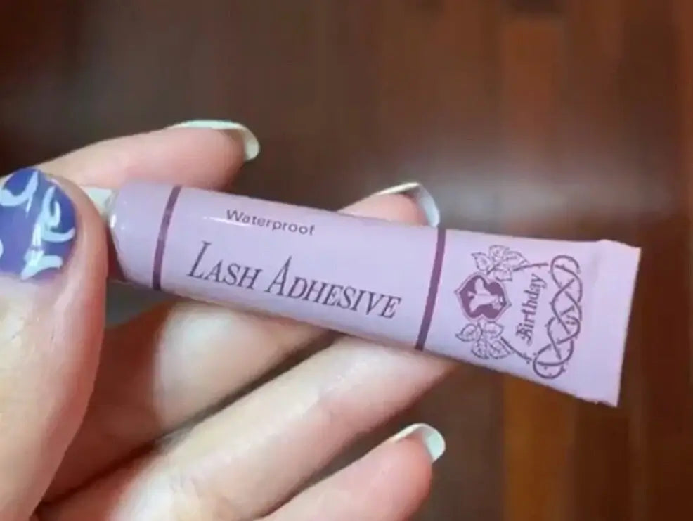 Birthday Lash Adhesive compact purple tube held in hand for false eyelash application