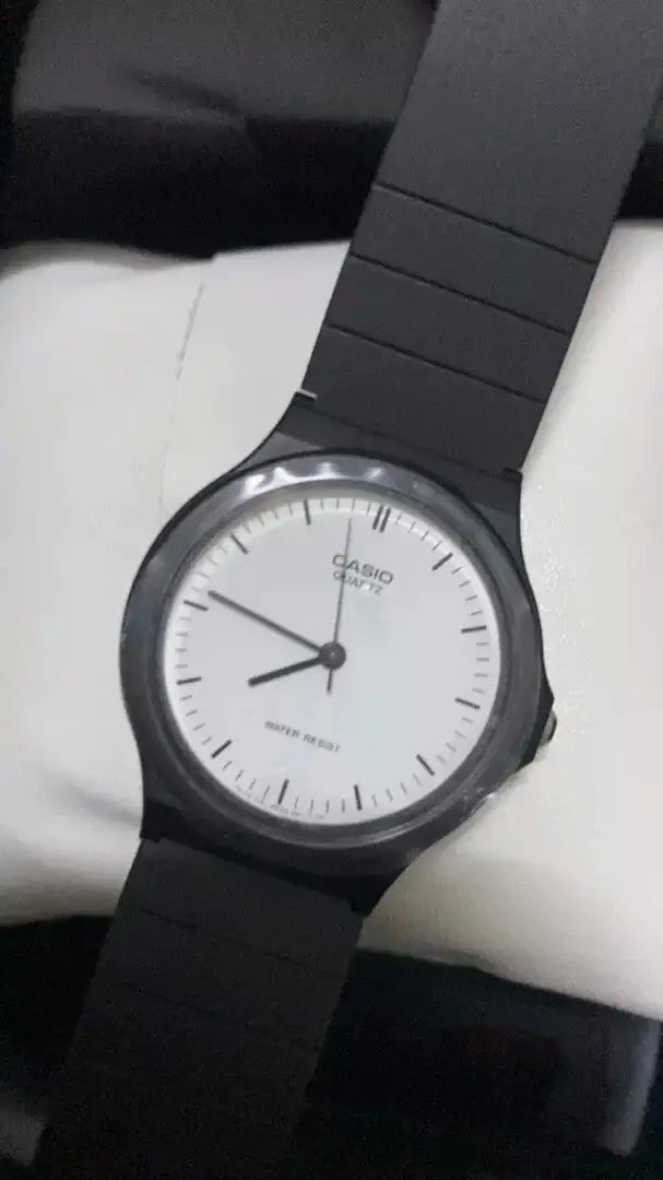 Casio MQ-24-7ELDF Watch displaying a white dial with black resin band, showcasing classic analog design and quartz precision.