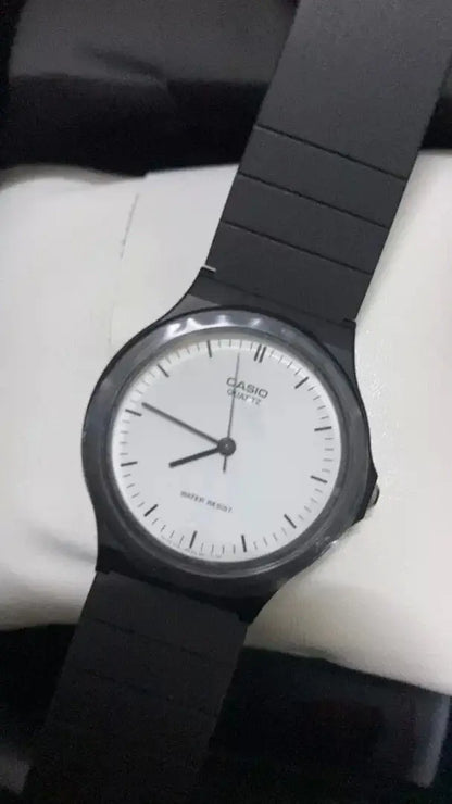 Casio MQ-24-7ELDF Watch displaying a white dial with black resin band, showcasing classic analog design and quartz precision.