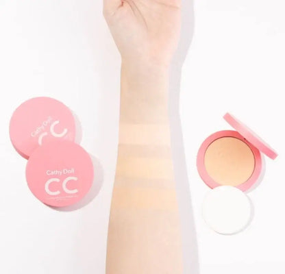 Arm shade swatches comparison alongside Cathy Doll CC Powder Pact compacts and applicator puff.