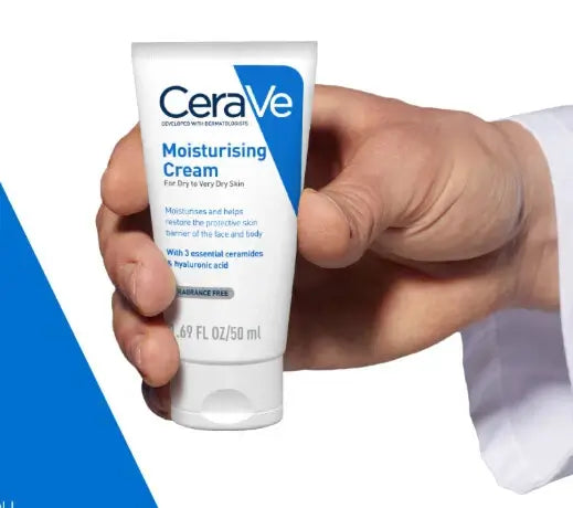 A person's hand holding a tube of CeraVe Moisturising Cream.