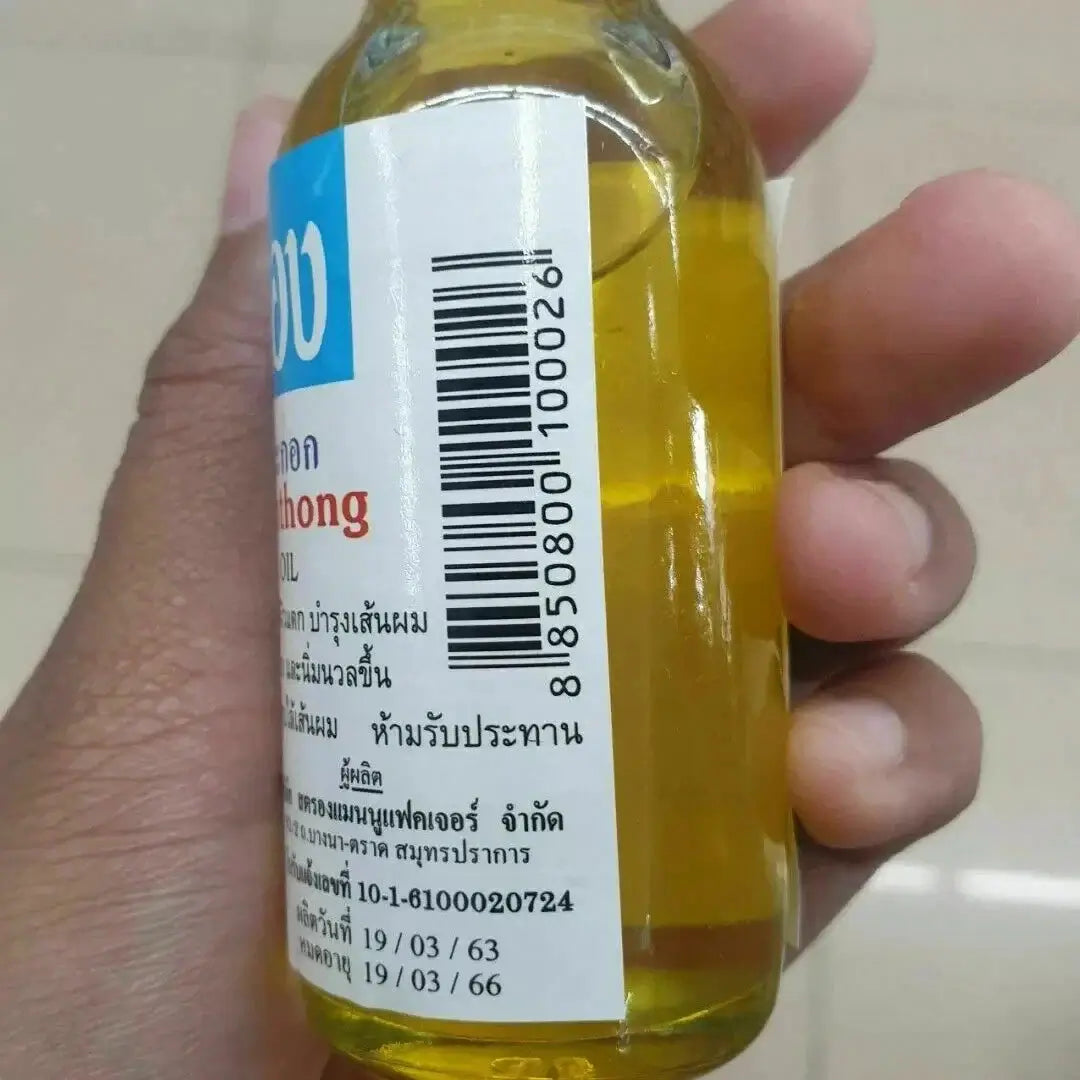 Chumpathong Olive Oil bottle held in hand, perfect for nourishing hair and skin spa care.