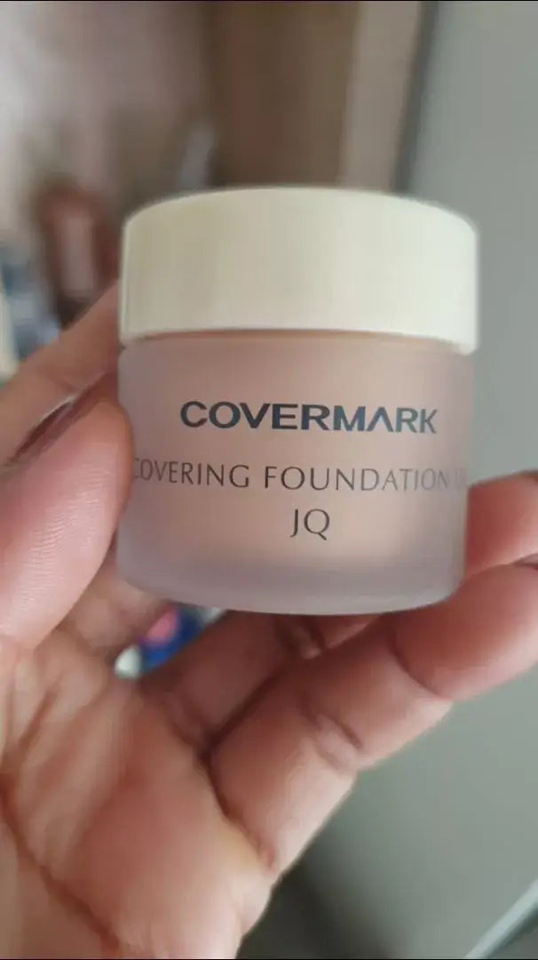 Covermark Foundation UV JQ in a hand, waterproof cream concealer in stylish jar packaging.