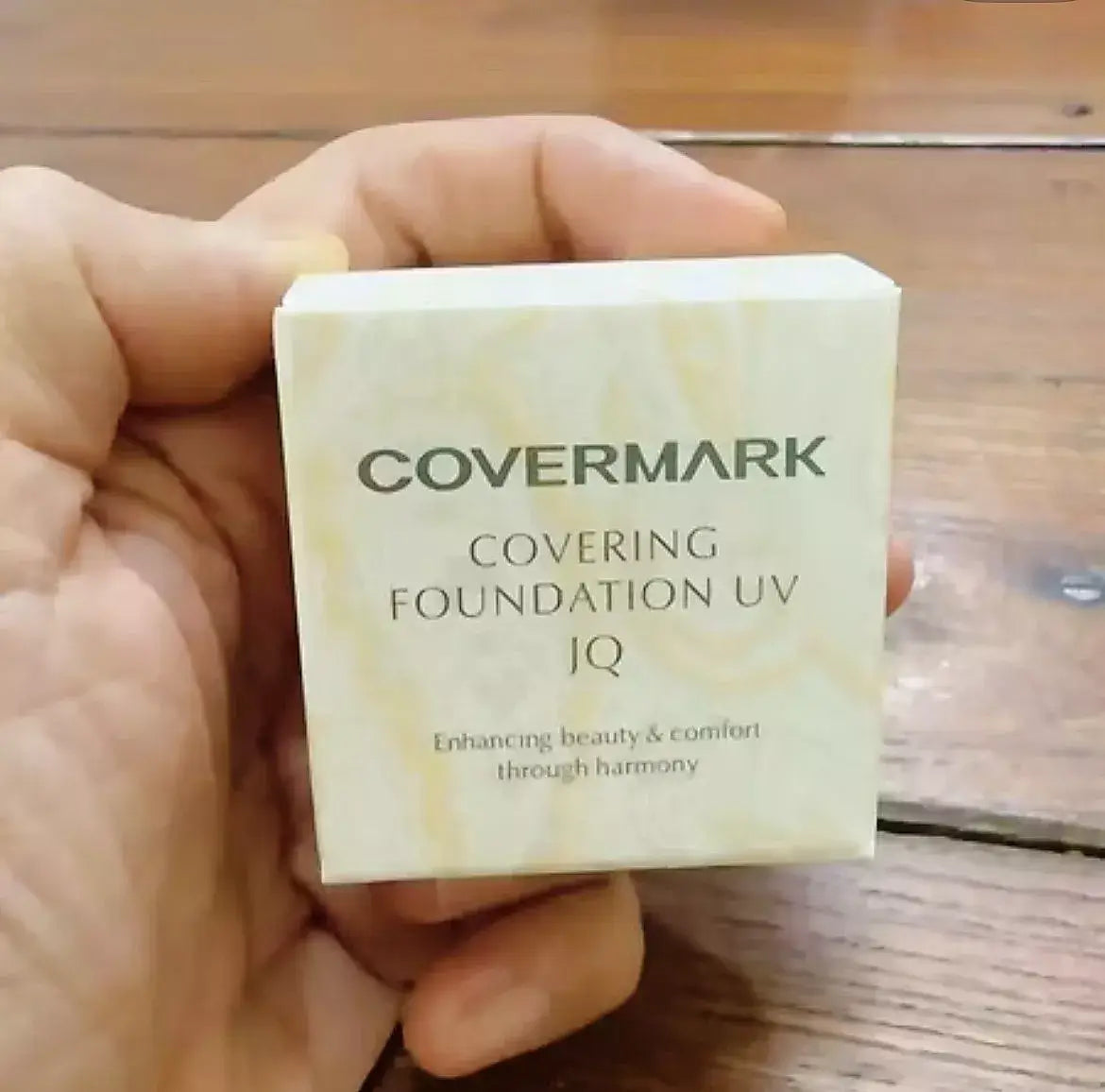 Covermark Foundation UV JQ packaging in hand, showcasing waterproof cream concealer for high coverage.
