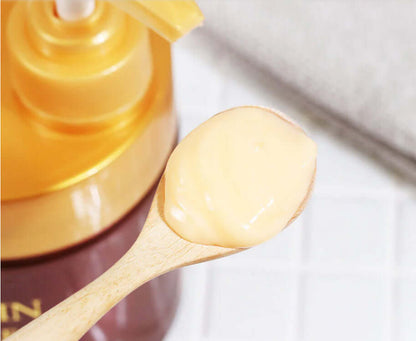 Creamy texture of Cruset Keratin Complex hair mask scooped onto a wooden spoon next to the product jar.