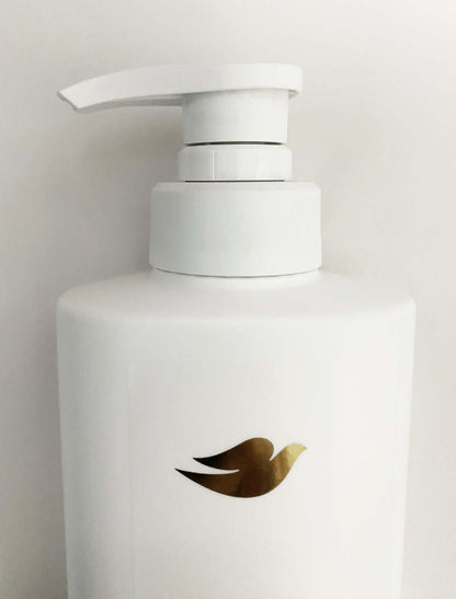Dove Elastin Shampoo bottle with pump top and gold logo on white container.