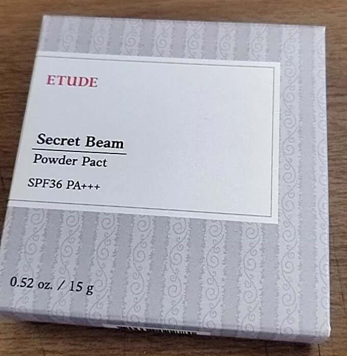 Etude Secret Beam Powder Pact SPF36 PA+++ 0.52 oz. 15 g face makeup packaging on wooden surface.