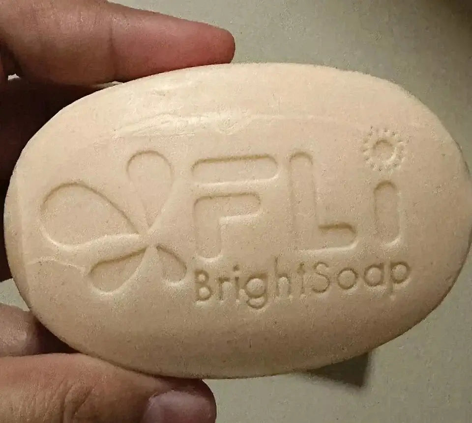 FLi Bright Herbal Soap bar showing logo in hand with smooth texture and natural color for cleansing skin.