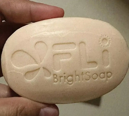 FLi Bright Herbal Soap bar showing logo in hand with smooth texture and natural color for cleansing skin.