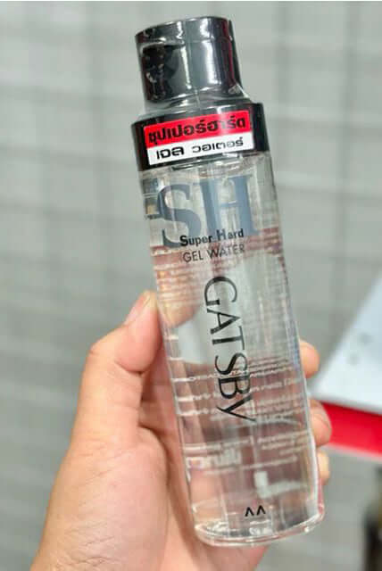 GATSBY Gel Water Super Hard Hair Styling Care for Men in a clear bottle held by a hand, Mandom 200ml.