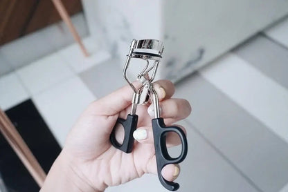 GINO McCRAY Eyelash Curler held in hand ready for application
