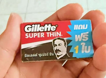 Hand holding a single pack of Gillette Super Thin double edge razor blades