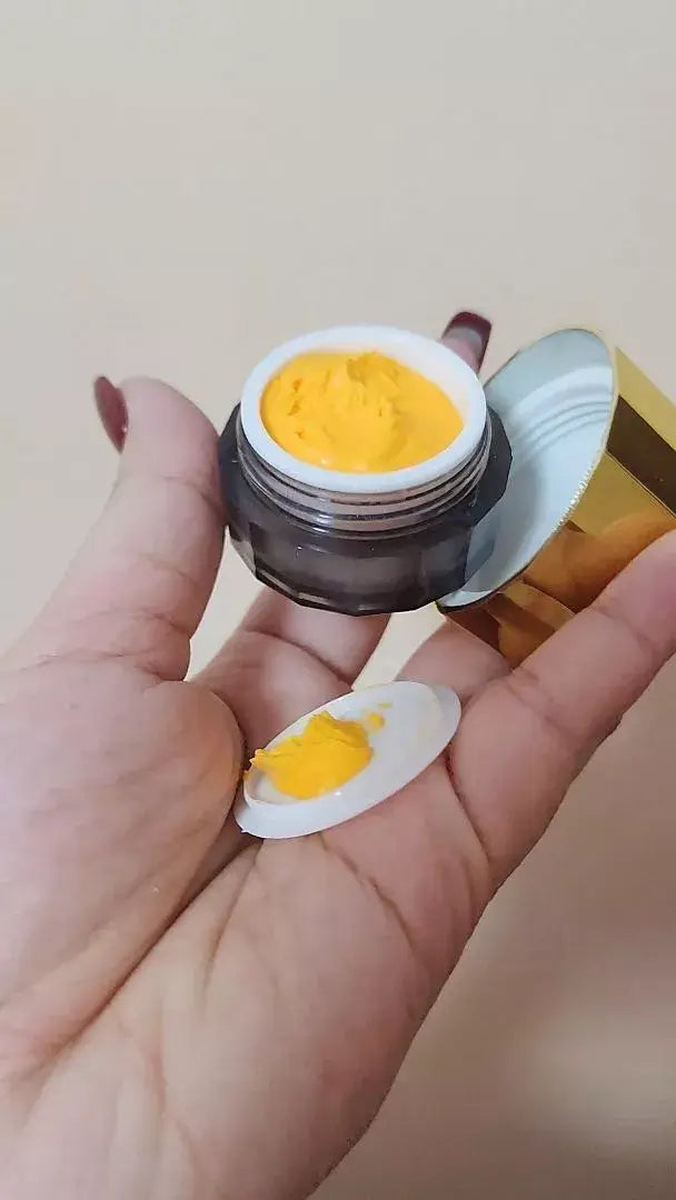 Herbal Curcumin Cream in a jar with yellow turmeric cream being held in hand for radiant skin.
