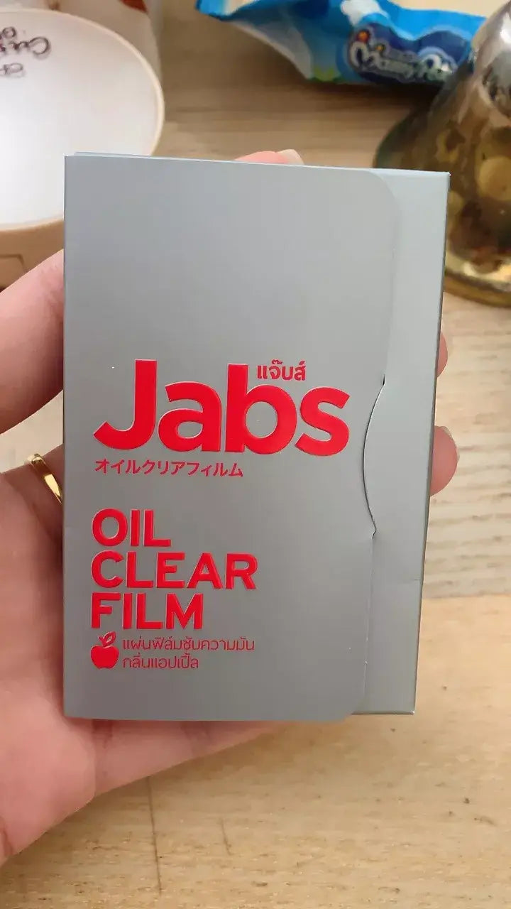 Close-up shot of the Jabs Oil Clear Film product case, held by a hand.