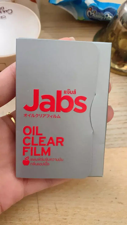Close-up shot of the Jabs Oil Clear Film product case, held by a hand.