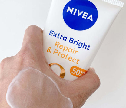 NIVEA Repair Protect Body Serum tube shown in a hand, featuring Extra Bright and SPF50, promoting radiant skin.