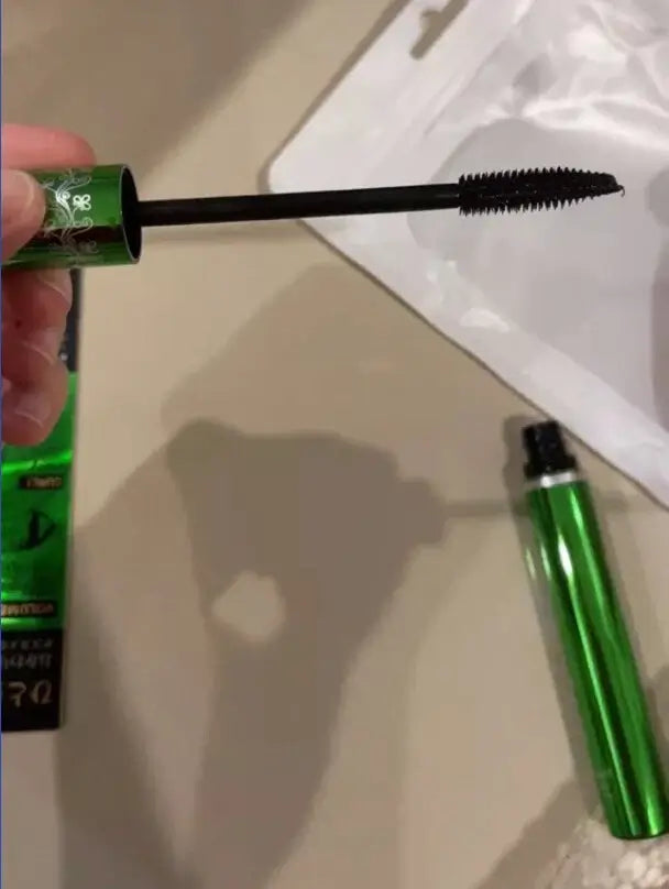 ODBO BQ Cover Mascara brush being pulled out of the green metallic tube showing the black formula.