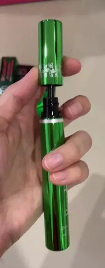 A hand holding the green metallic tube of ODBO BQ Cover Mascara.