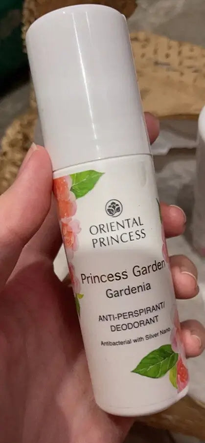 Hand holding Oriental Princess Garden Gardenia deodorant bottle showing floral label