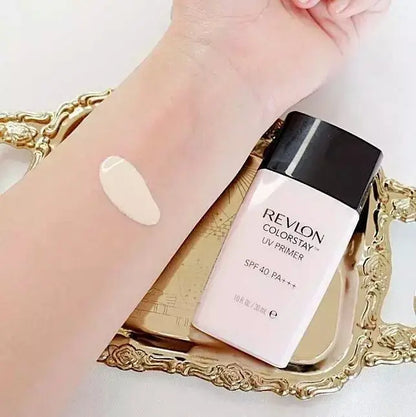 Revlon ColorStay UV Primer bottle next to an arm showing a swatch of the liquid makeup base on the skin.