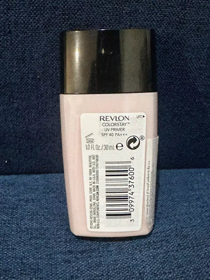 Revlon ColorStay UV Primer bottle back view showing the barcode, ingredients, and product details on a dark blue texture background.