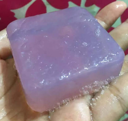 Translucent purple Royal Beauty Hyaluron Soap bar held in a hand.