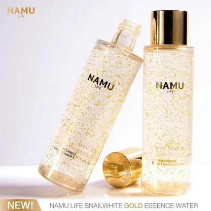 Snailwhite Gold Essence Water bottles displayed on a gold accented reflective surface