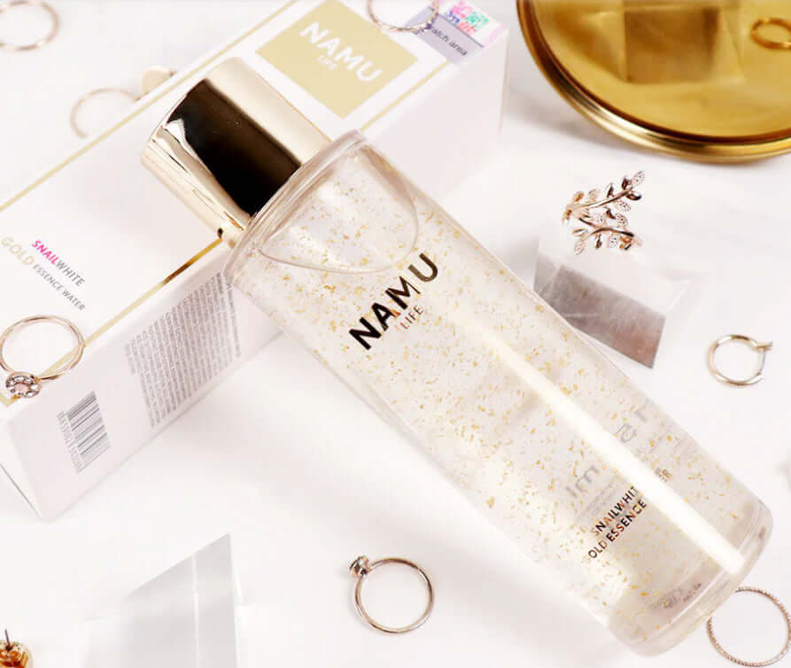 Snailwhite Gold Essence facial skin care lotion with 24K gold flakes in a stylish bottle, 150ml.