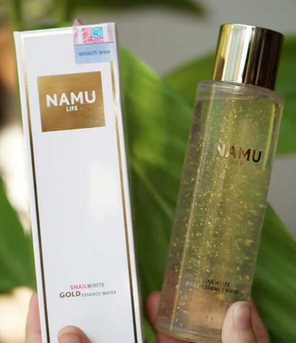 Snailwhite Gold Essence bottle with product packaging carton held in hand
