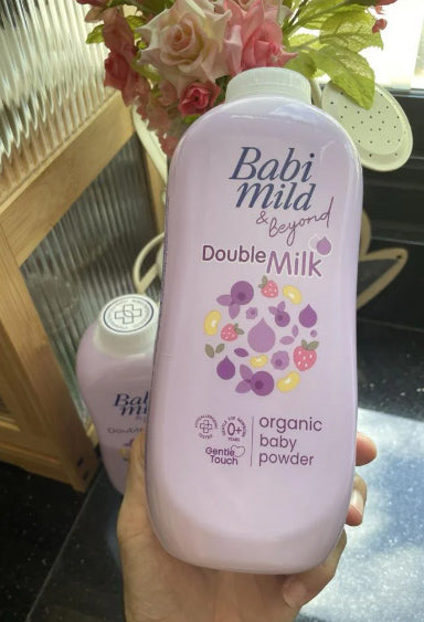 Babi Mild Double Milk Powder bottle lifestyle hand holding view