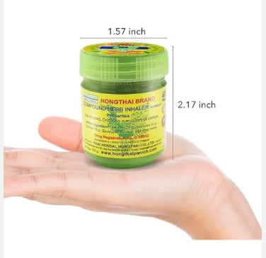 Hand holding a jar of Hong Thai Herbal Balm showing its compact 5.5 cm size.