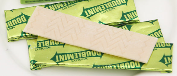 Unwrapped Wrigley Doublemint Chewing Gum sticks displayed on white surface, classic mint flavor.
