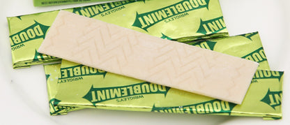 Unwrapped Wrigley Doublemint Chewing Gum sticks displayed on white surface, classic mint flavor.