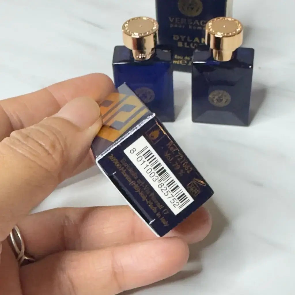 Versace Dylan Blue Pour Homme EDT mini spray in hand, showcasing packaging and barcode.