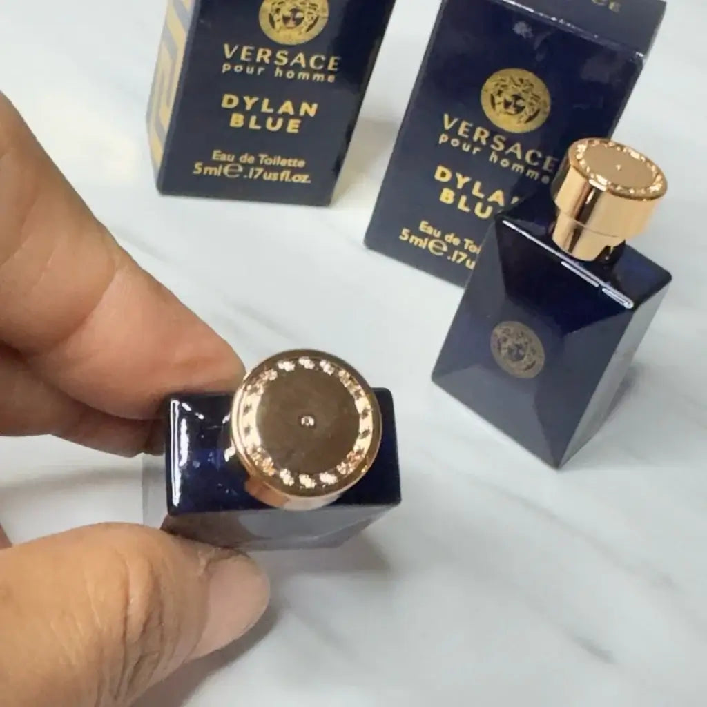 Close-up of Versace Dylan Blue Pour Homme EDT mini spray bottle, showcasing its elegant cap and packaging.