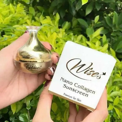Person holding a gold jar and white box of Wise Nano Collagen Sunscreen against green leaves background.