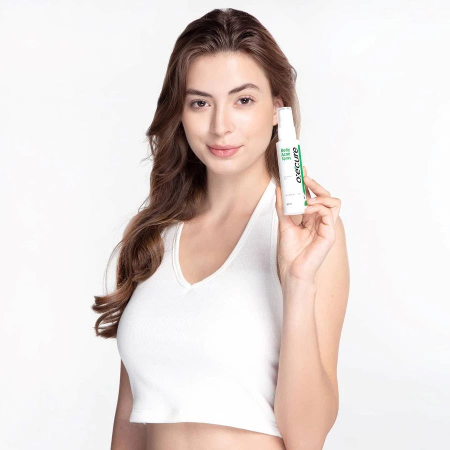 Oxe Cure Body Acne Spray held by woman showing smooth clear skin