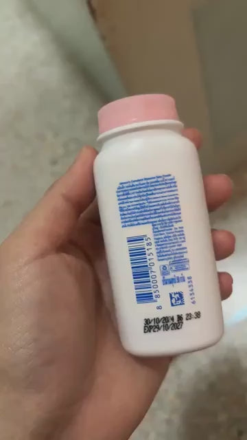 Hand holding back label of Johnson's Baby Powder showing barcode and ingredients